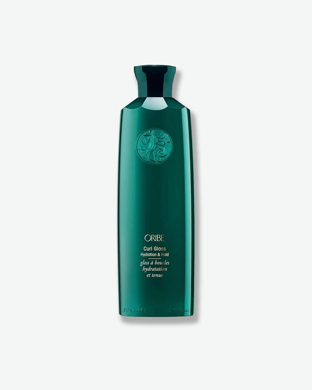 Green bottle of Oribe hair product on a white background