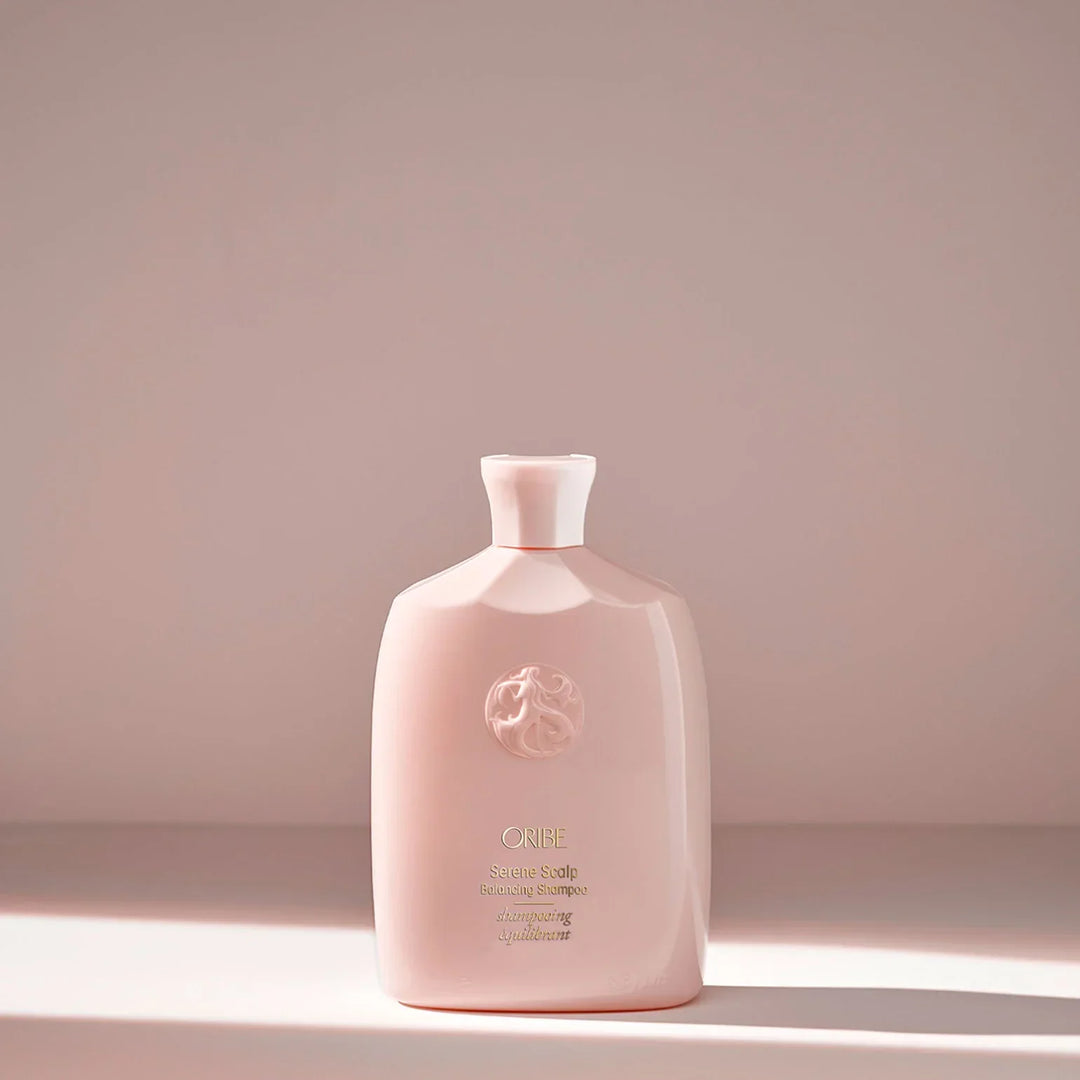 Pink bottle with a brand logo on a light pink background