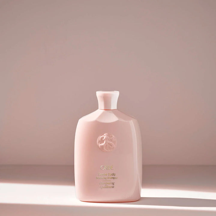 Pink bottle with a brand logo on a light pink background