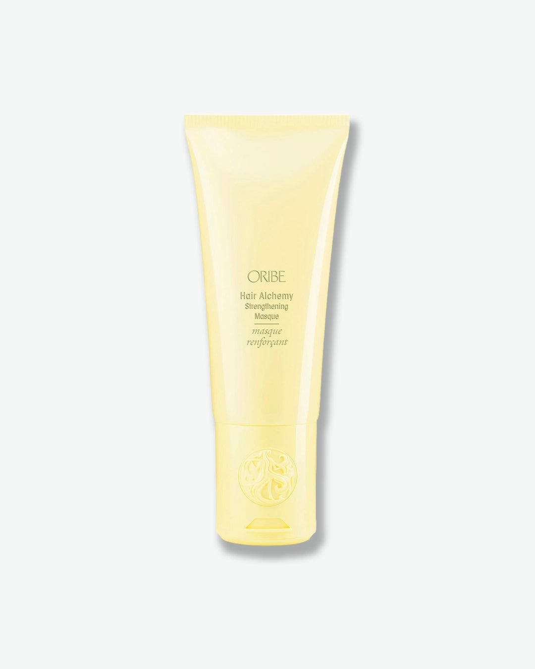 Yellow tube of Oribe hair product on a white background