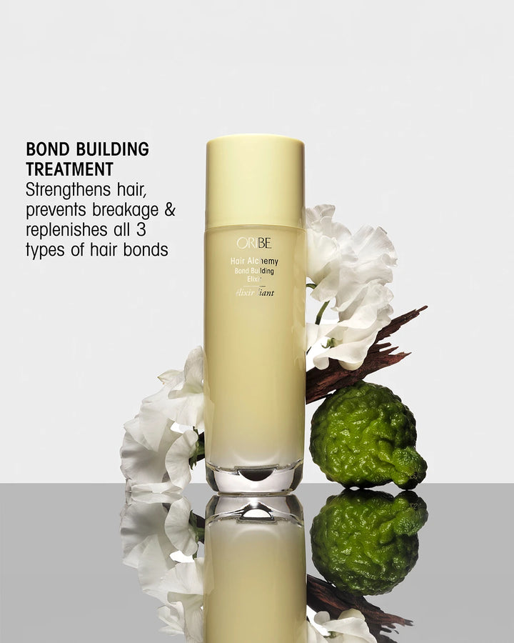 Hair care product with green fruit and white flowers on a reflective surface
