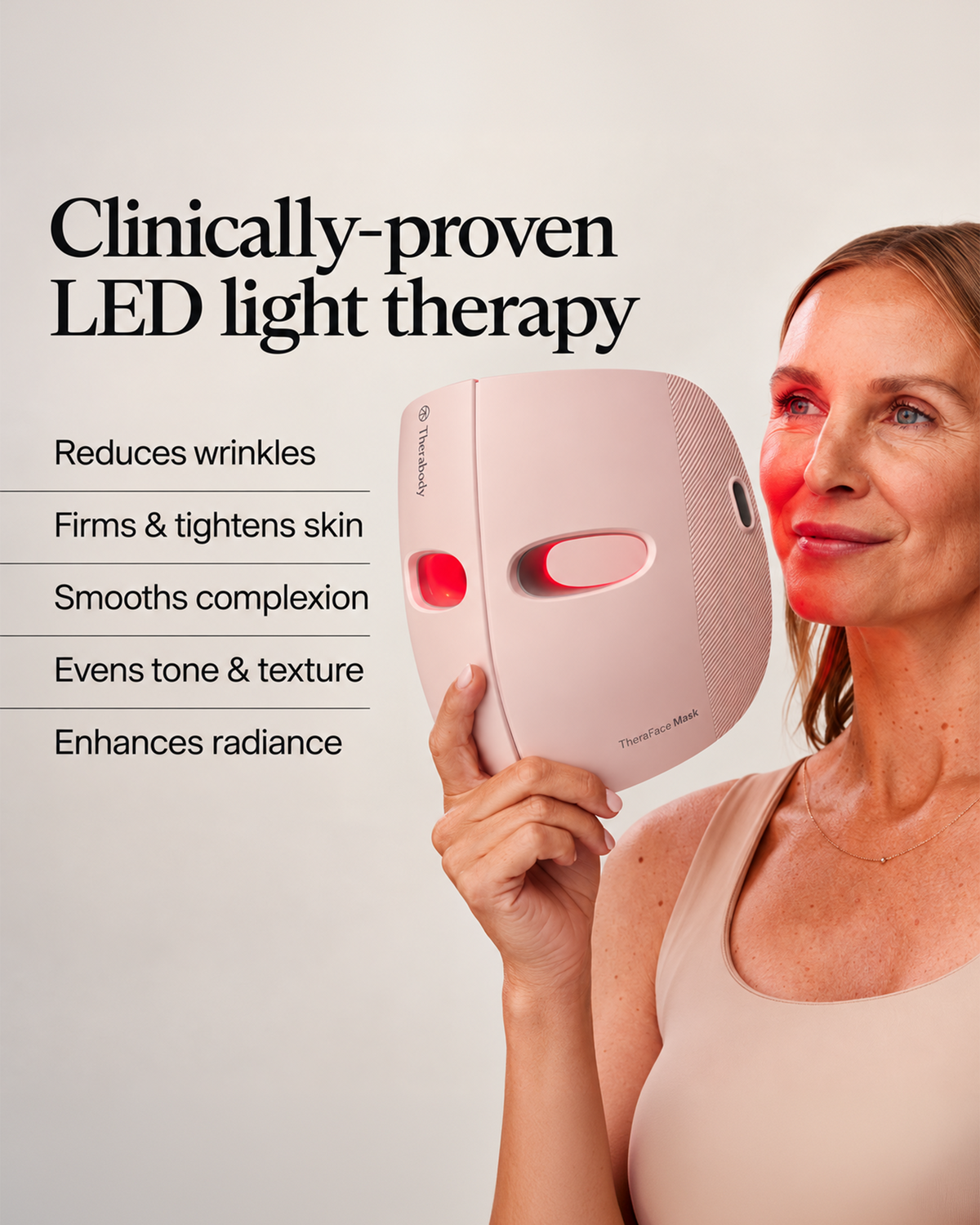 Woman holding a Therabody TheraFace Mask beside her face with red LED light illuminating her skin, alongside benefits including reducing wrinkles, firming and tightening skin, smoothing complexion, evening tone and texture, and enhancing radiance.