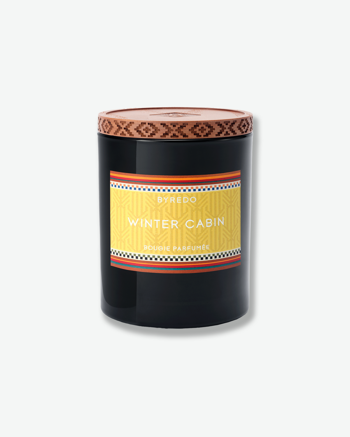 Byredo Winter Cabin candle in a black glass vessel with a patterned wooden lid and yellow label.
