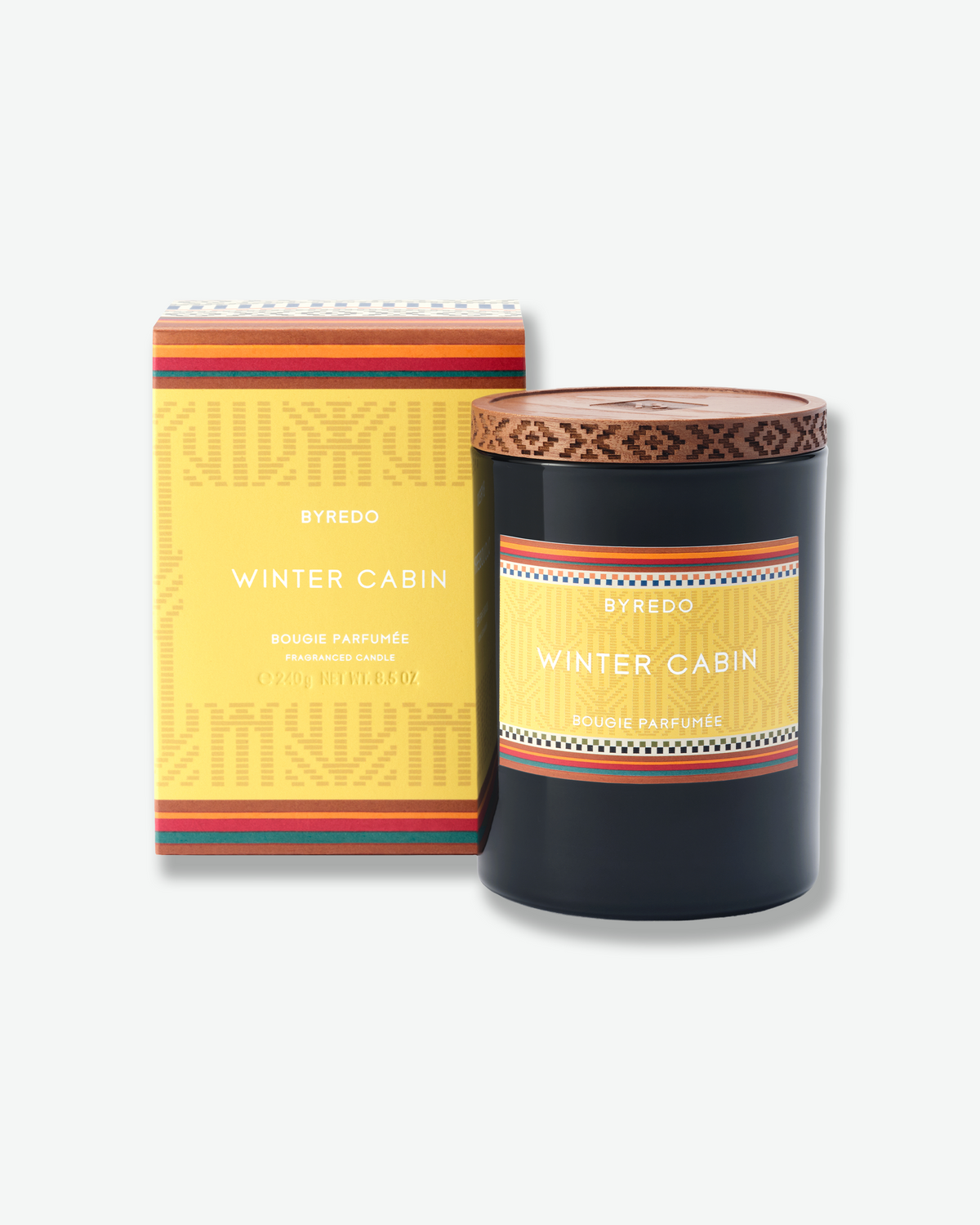 Byredo Winter Cabin candle displayed beside its coordinating yellow presentation box.