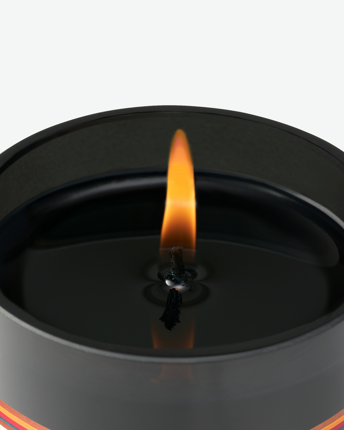 Close-up of the lit wick and flame inside the Byredo Cloudberry scented candle.
