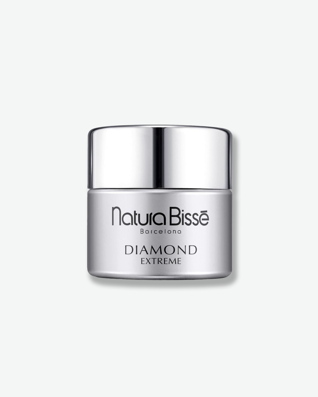 ront view of a Natura Bissé Diamond Extreme cream jar against a plain gray background. The cylindrical container features a matte metallic silver body with minimalist black text branding, topped with a matching high-shine, polished silver cap.