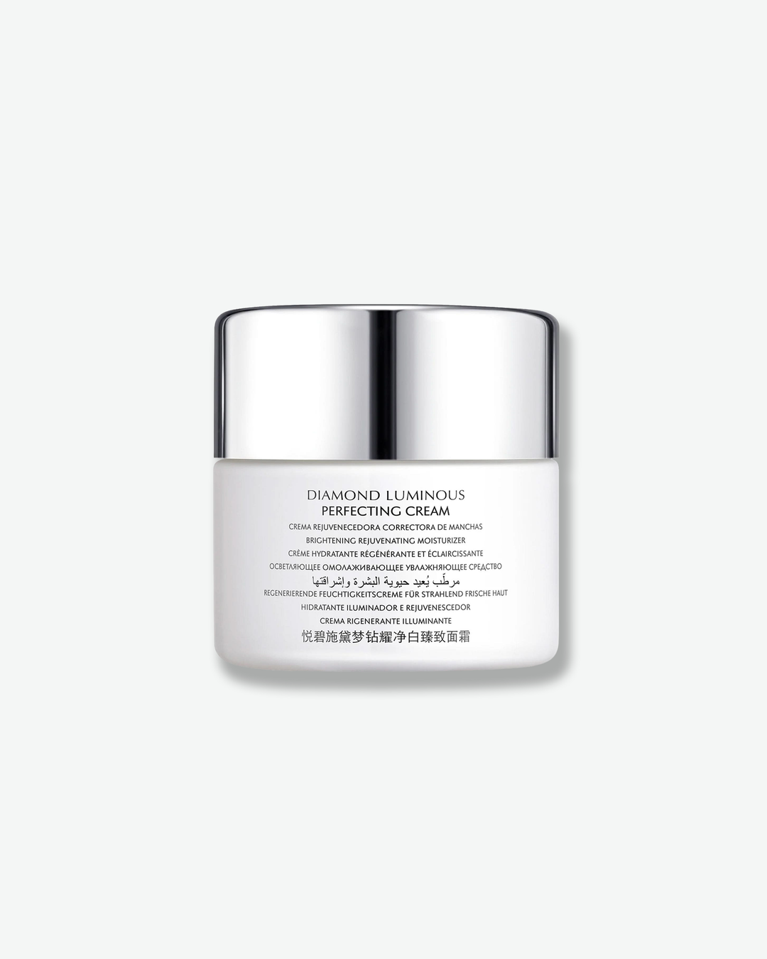 Front view of a Natura Bissé Diamond Luminous Perfecting Cream jar against a plain gray background. The matte white cylindrical jar displays detailed multi-lingual product descriptions printed in a subtle grey font across the front beneath a high-shine silver cap.