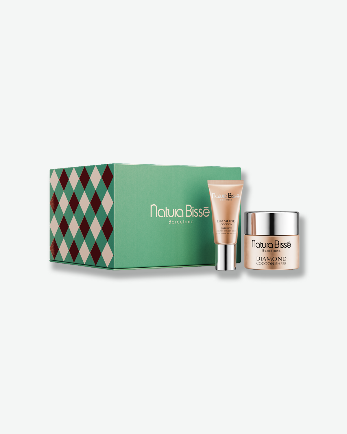 Natura Bissé Diamond Cocoon skincare gift set featuring Diamond Cocoon Sheer Cream and Sheer Eye Cream, displayed alongside a green holiday gift box with a festive diamond pattern.