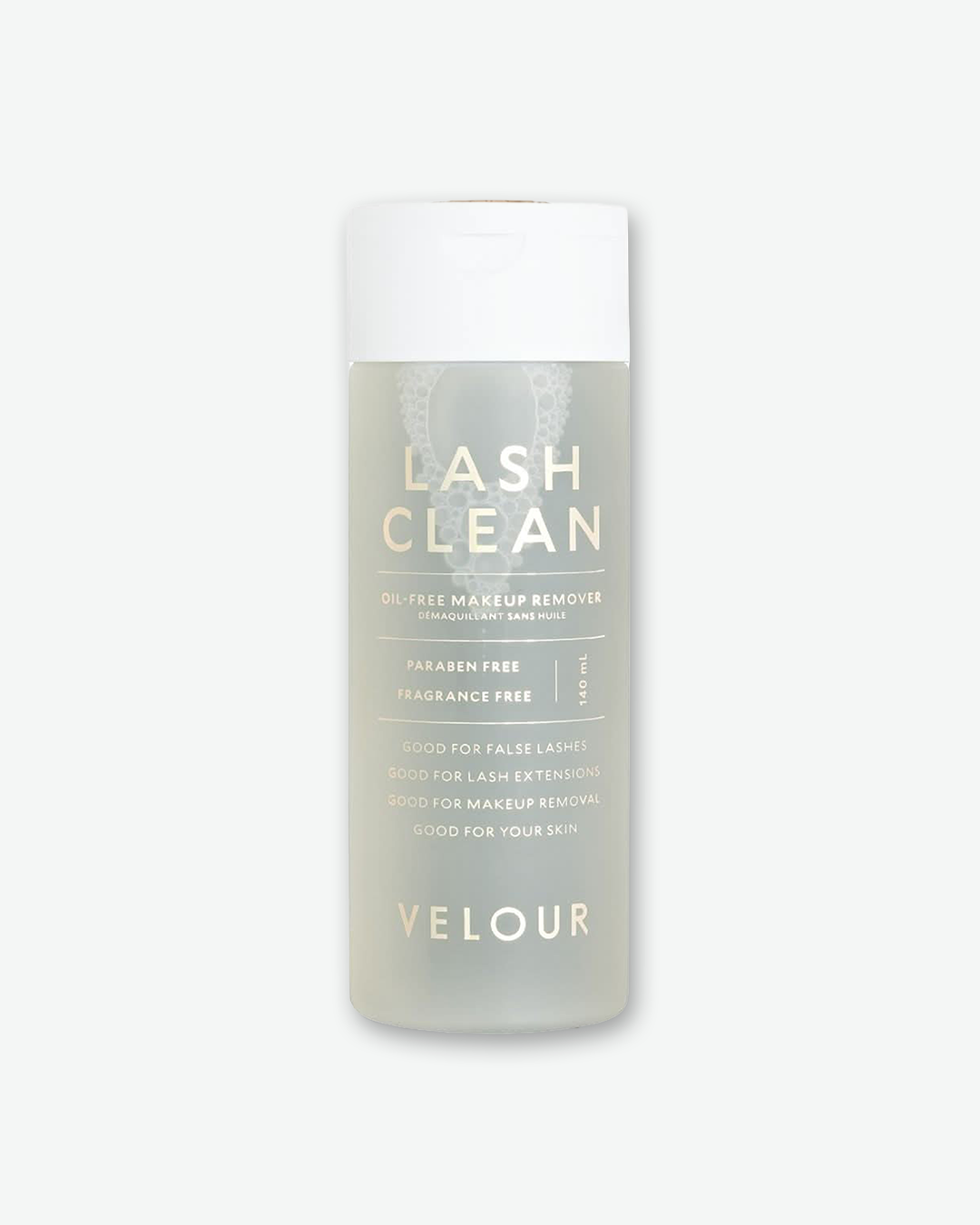 Product shot featuring a bottle of Velour Lash Clean Oil-Free Makeup Remover standing next to its vertical cardboard outer box against a plain gray background. The white box on the left and the frosted translucent bottle on the right both feature elegant, metallic rose-gold typography and descriptions.