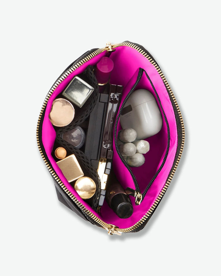 Pink makeup pouch with various cosmetic items on a white background