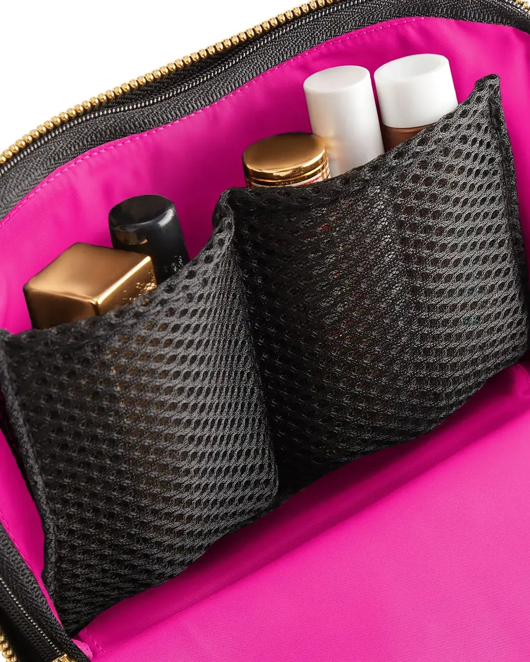 Pink makeup bag with black mesh pouches containing cosmetic items.