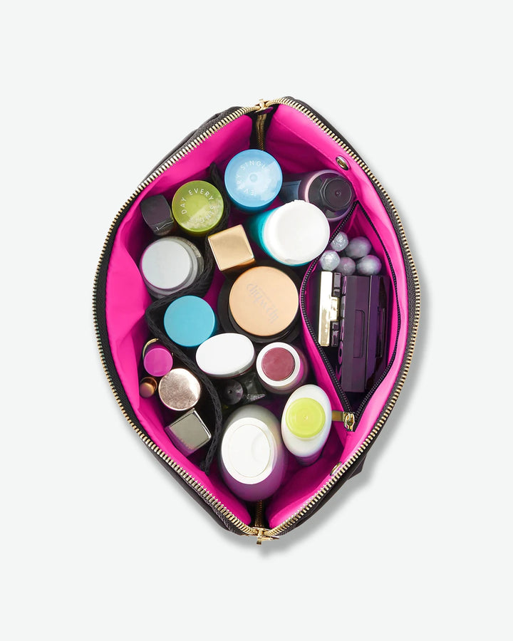 Makeup bag with various cosmetic items on a light gray background
