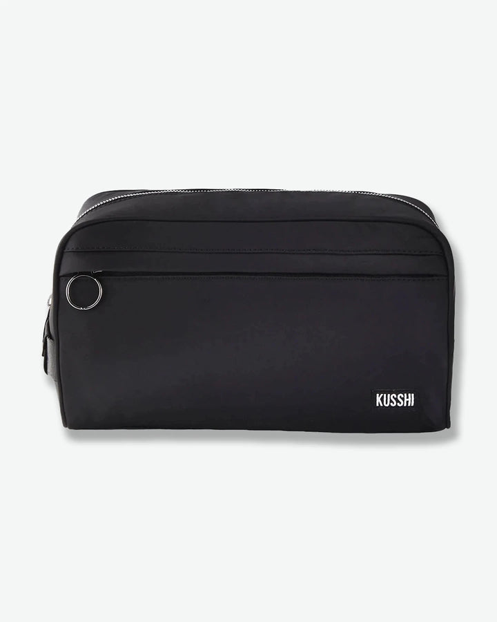 Black toiletry bag with 'KUSSHI' branding on a white background
