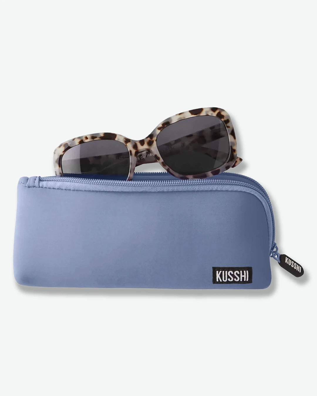 Blue sunglasses case with tortoiseshell sunglasses on a light gray background