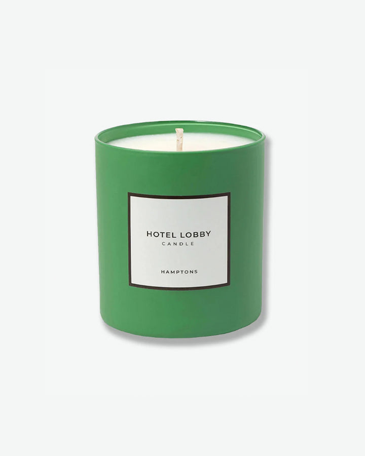 Hotel Lobby Candle Hamptons scented candle in a matte kelly green glass tumbler with a square white label, isolated against a light grey background.