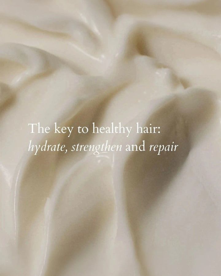 Close-up of creamy hair product with text overlay on a beige background