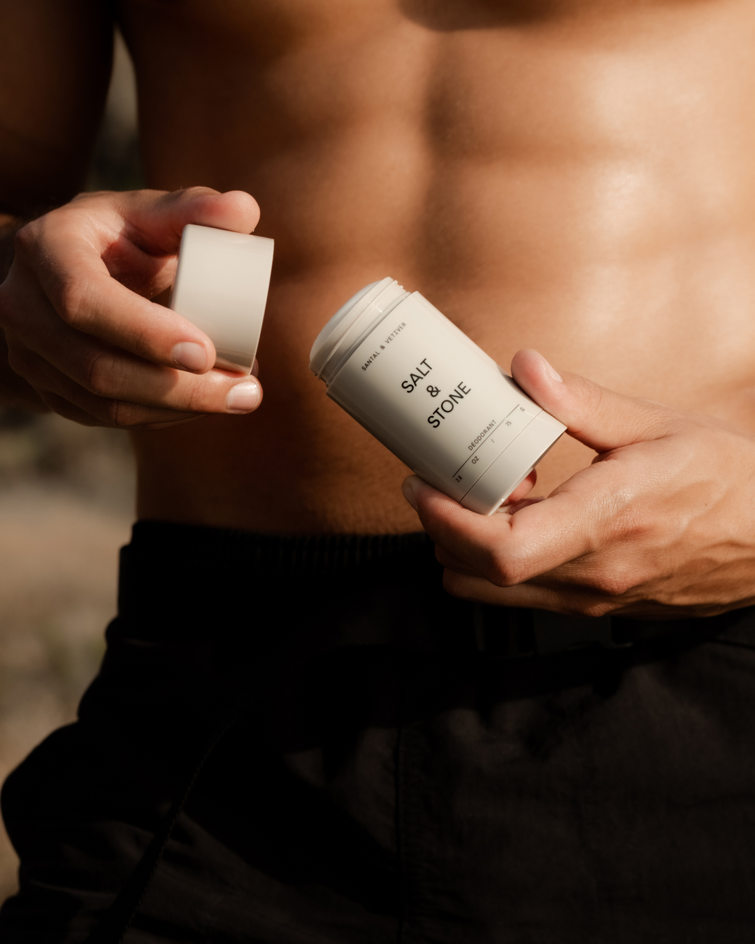 Person holding an open Salt & Stone deodorant stick.