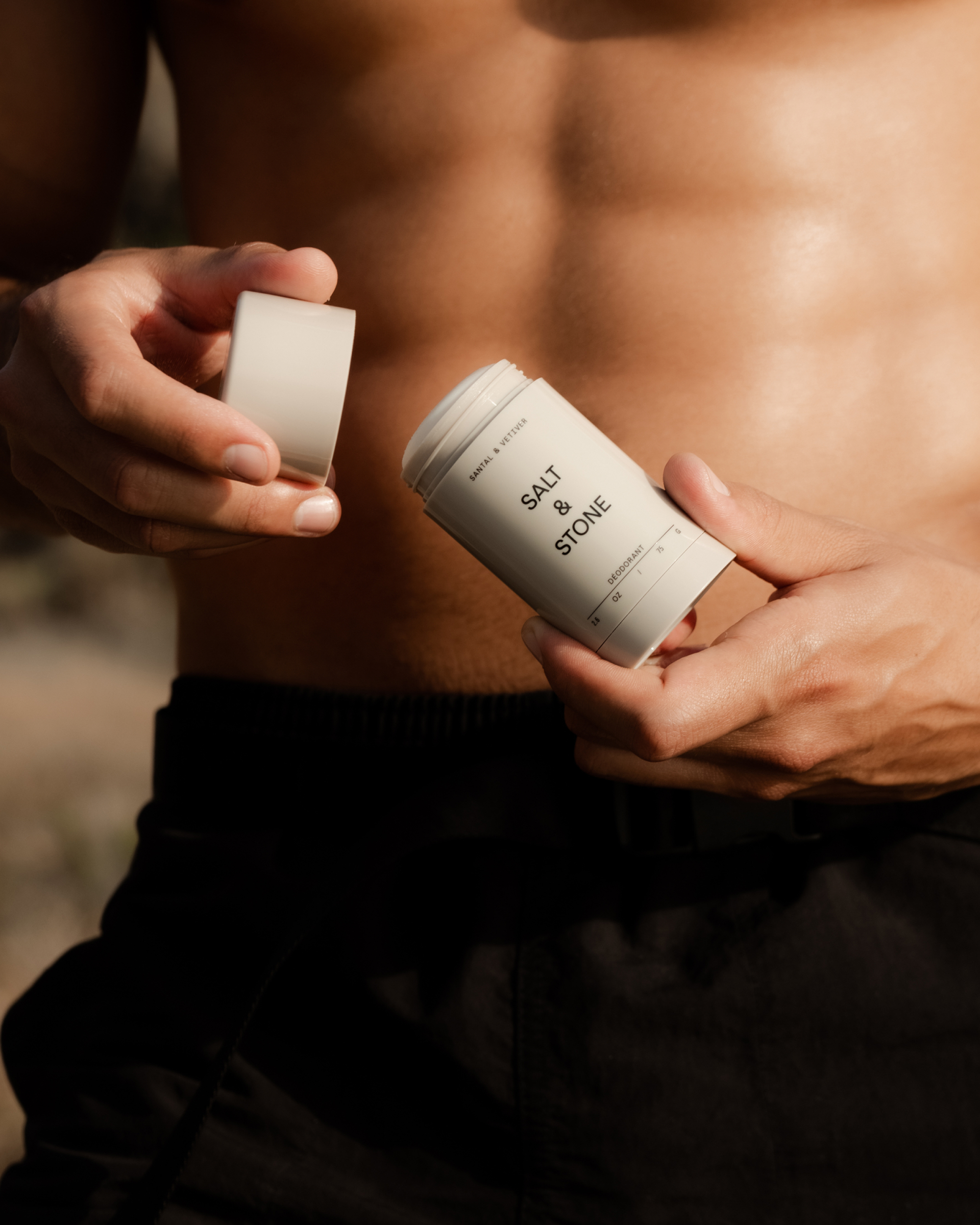 Person holding an open Salt & Stone deodorant stick.
