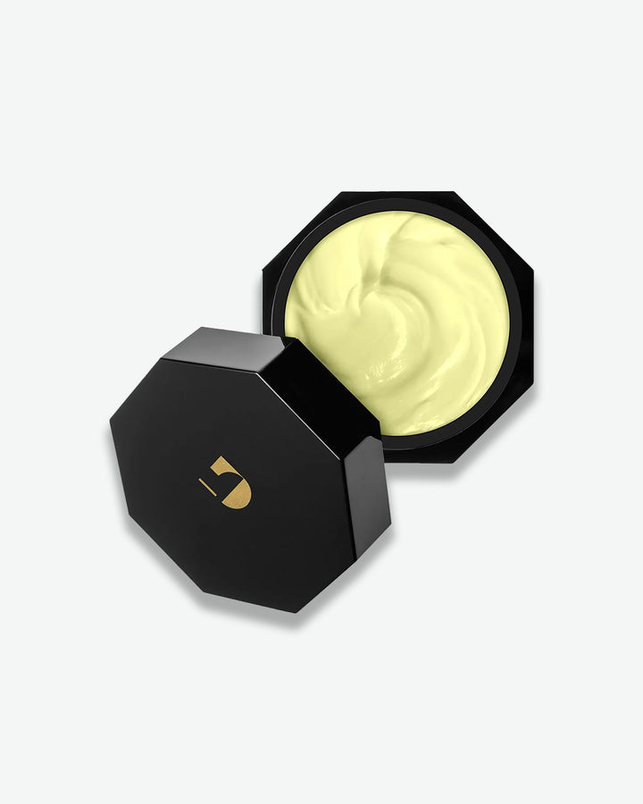 Black container with a yellow cream inside on a white background