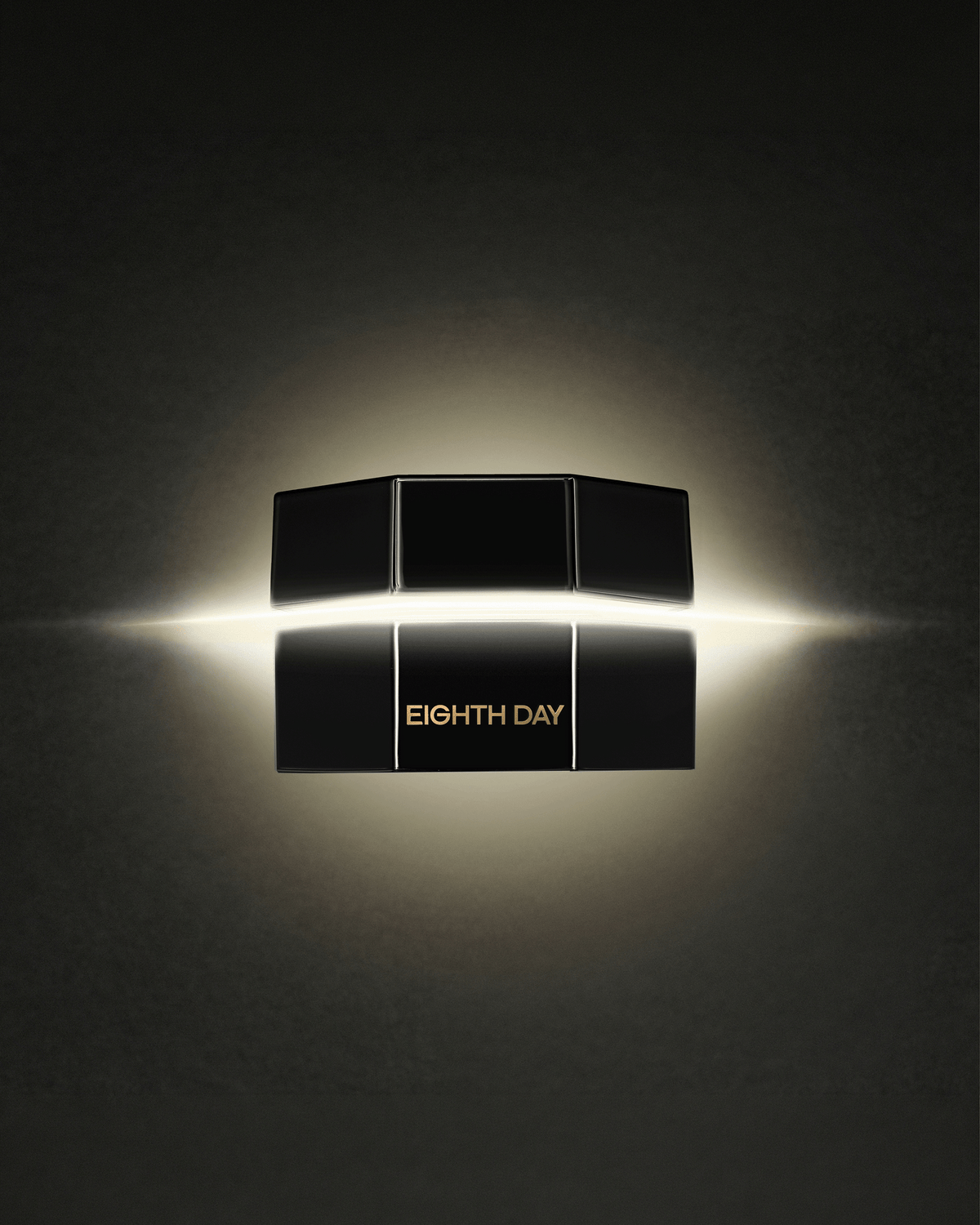 Black Eight Day skincare packaging displayed against a dark background with a warm glowing light behind the product.