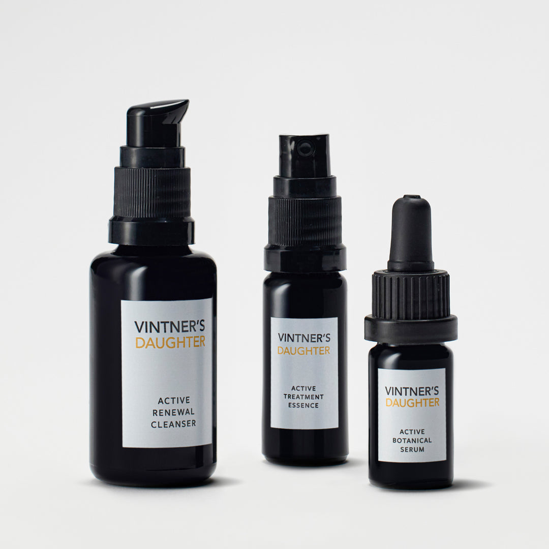 Three black bottles of Vintner's Daughter skincare products on a light gray background