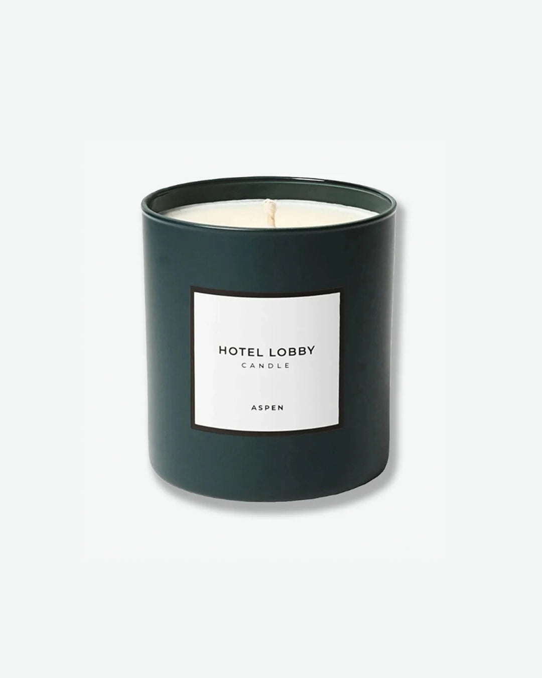 Hotel Lobby Candle Aspen scented candle in a matte forest green glass tumbler with a square white label, isolated against a light grey background.