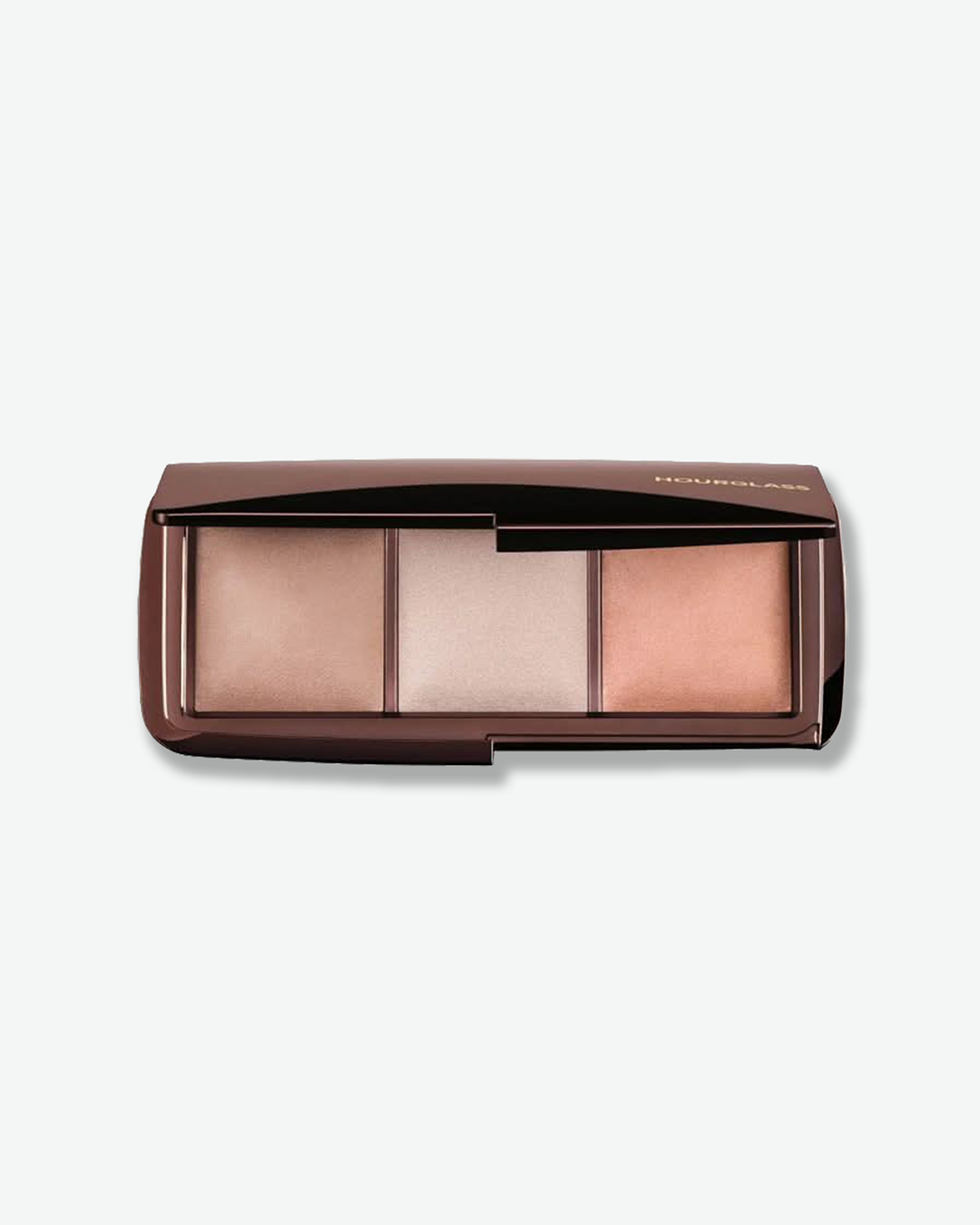 A top-down view of an open Hourglass Ambient Lighting Palette against a white background. The dark, glossy night-crimson compact houses three square pans of finishing powder in soft, light-diffusing shades of champagne, soft white, and pale rose pink.