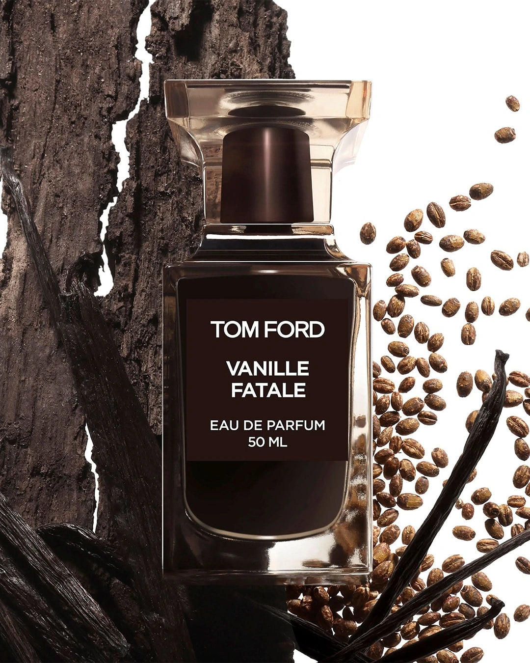 A textured product display featuring the Tom Ford Vanille Fatale 50ml bottle. The left half of the background is a thick piece of rough, dark brown tree bark intertwined with long, wrinkled black vanilla pods. On the right, a rainfall of small, textured golden-brown seeds falls down a stark white backdrop, emphasizing the raw ingredient notes.