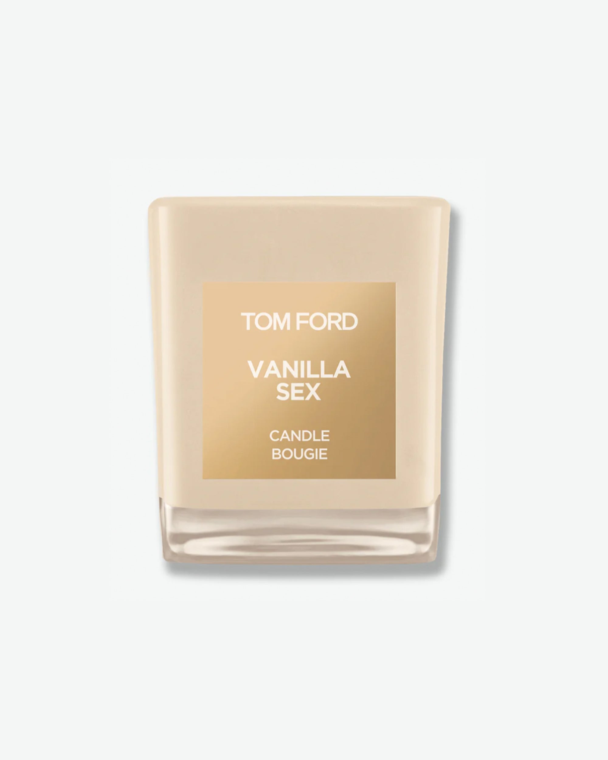 Product shot of a Tom Ford Vanilla Sex scented candle. The square-molded glass jar is a solid, warm cream or beige color with a glossy clear base. A square metallic gold label is centered on the front with white text that reads "TOM FORD VANILLA SEX CANDLE BOUGIE," shown against a clean, minimal light grey background.