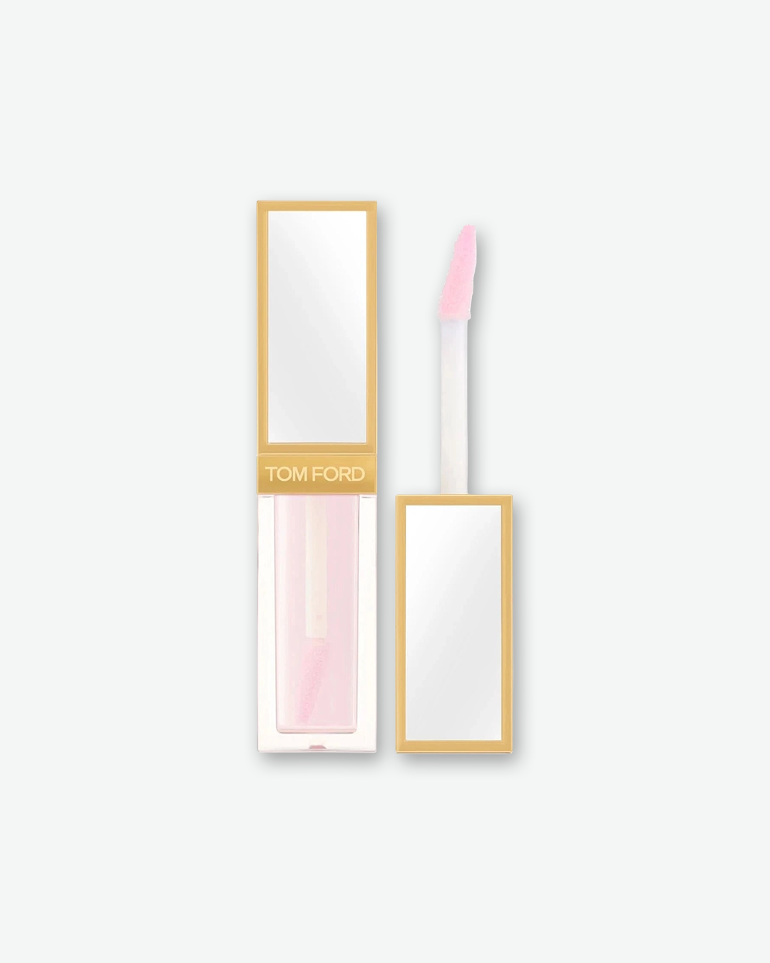 Tom Ford liquid lip product in a clear rectangular tube showing a pale pink formula, paired with a gold metallic cap featuring a built-in mirror panel, shown next to its unscrewed doe-foot applicator, isolated on a light grey background.