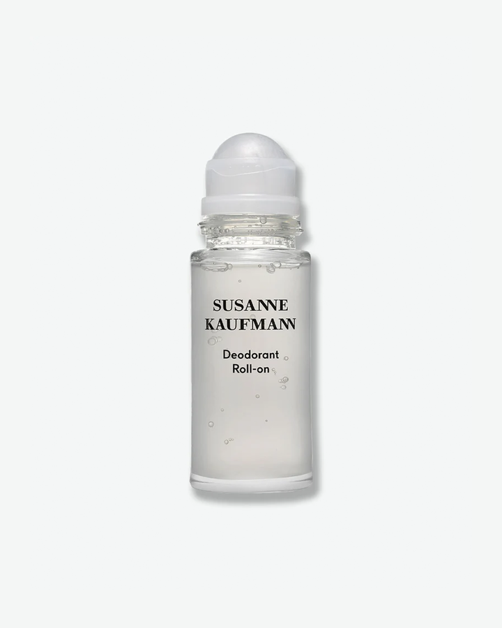 A product shot of a Susanne Kaufmann Deodorant Roll-on, centered against a plain light gray background. The cylindrical clear glass bottle reveals a semi-translucent liquid formula with small, suspended air bubbles. The front displays the brand name in black text above the words "Deodorant Roll-on," and the bottle is topped with a smooth, domed white roller-ball cap.