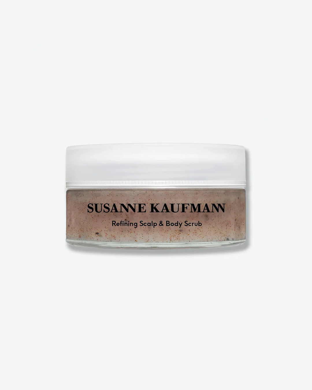 A product shot of a Susanne Kaufmann Refining Scalp & Body Scrub jar, centered against a plain light gray background. The shallow clear glass jar reveals a textured, light brown gel scrub with dark exfoliating particles suspended inside. It is sealed with a flat, frosted white cap, and the front features clean black typography detailing the brand name and product title.