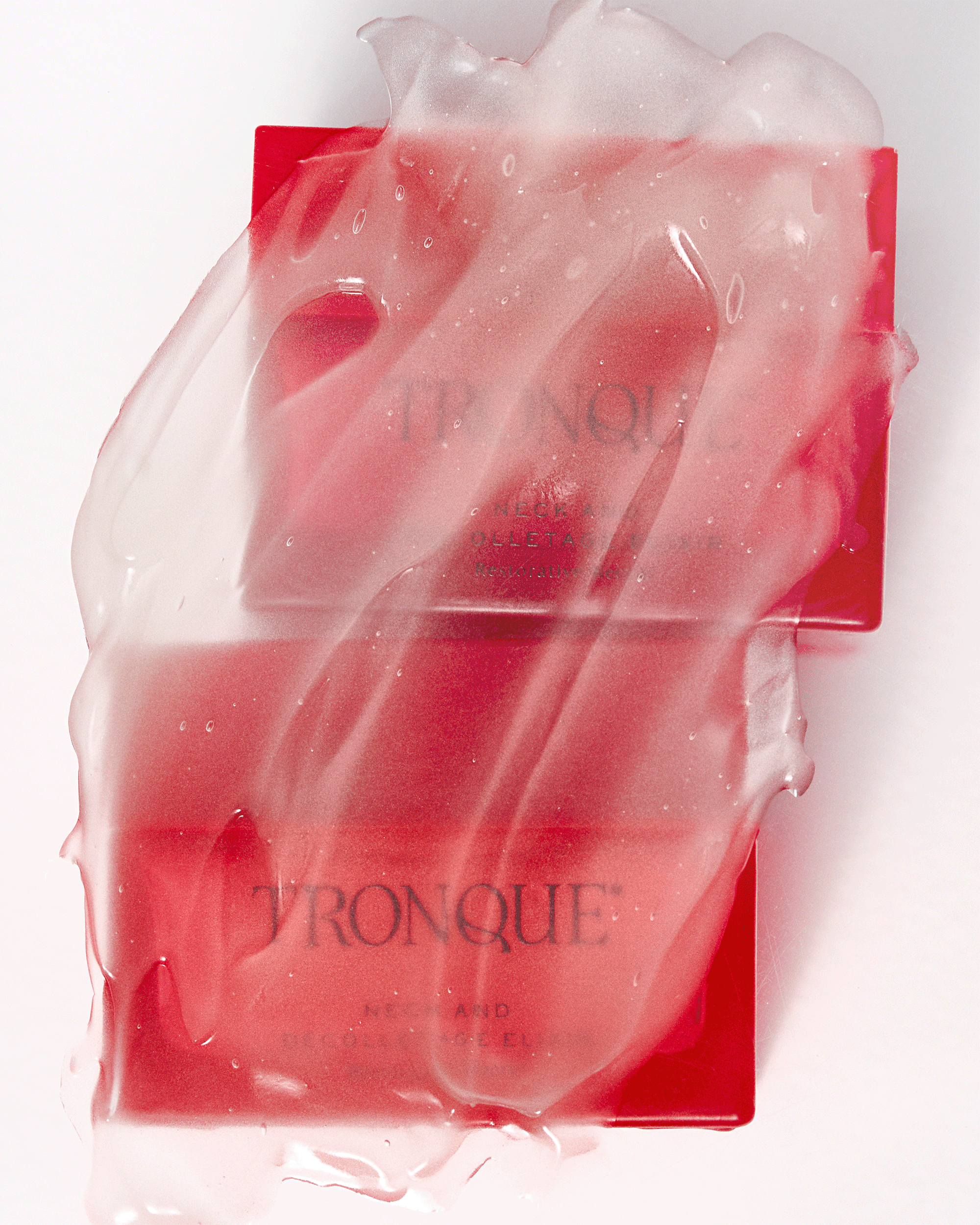 Artistic close-up of two red Tronque Neck and Décolletage Elixir jars partially covered in a glossy translucent gel texture.