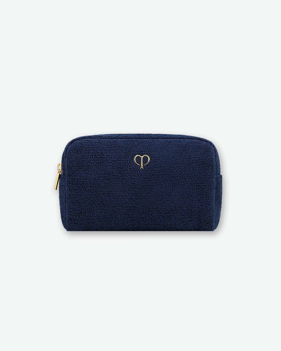 A textured, dark navy blue cosmetic pouch by Clé de Peau Beauté, centered on a solid white background. The pouch is rectangular with rounded top corners, made from a soft bouclé or terry cloth fabric, and features a minimalist, metallic gold brand logo in the center with a matching gold zipper on the left side.